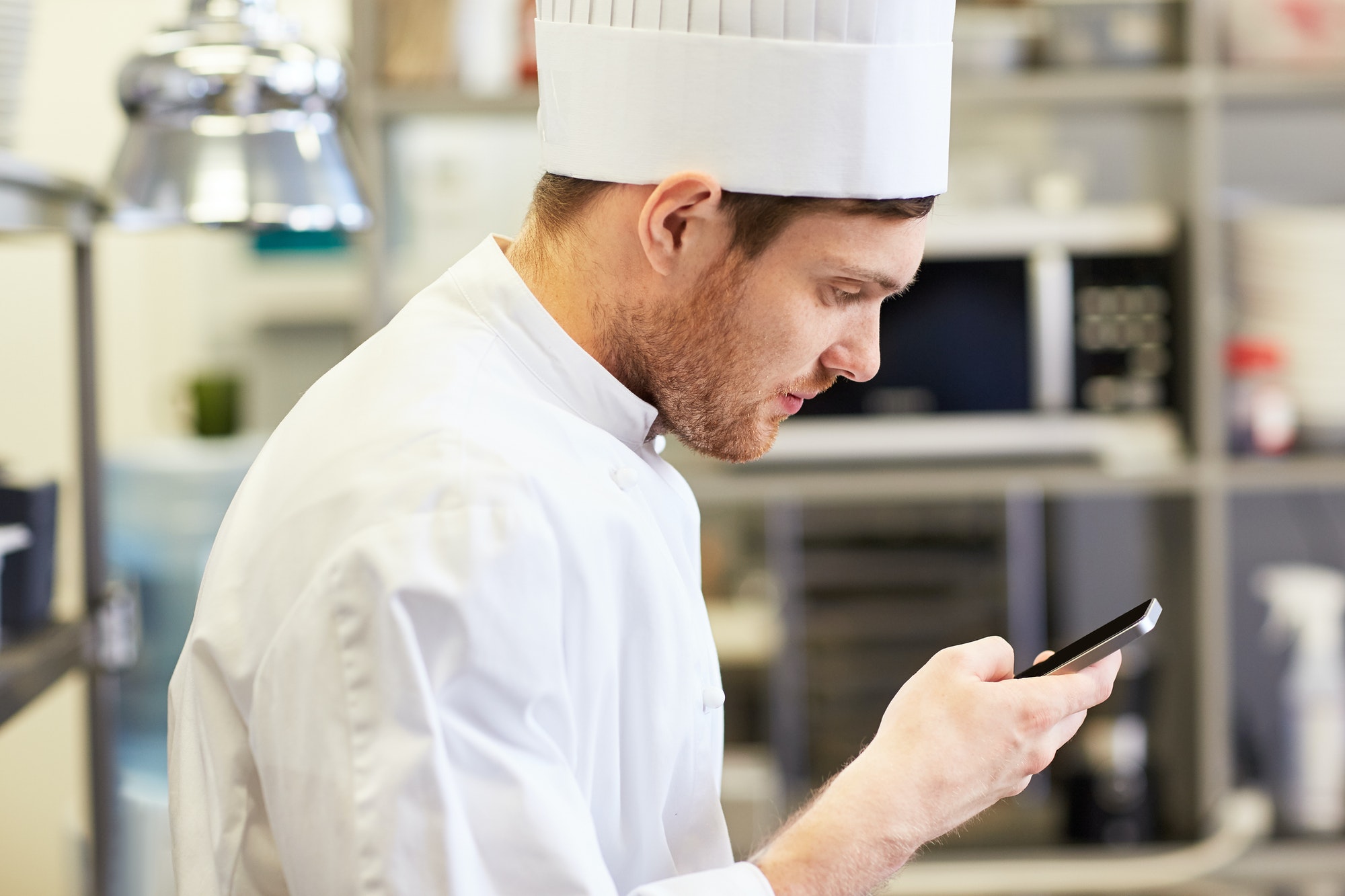 close-up-of-chef-with-smartphone-at-kitchen.jpg